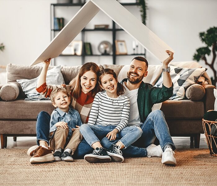 Familie sitzt im Wohnzimmer und symbolisiert Sicherheit und Wohnqualität in einem Ziegelmassivhaus von Binder Bau
